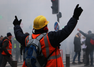 Un manifestant en tenue de travail lève les bras en signe de joie après l&#039;explosion d&#039;un pétard lors de la manifestation contre la réforme des retraites du 5 décembre 2019.